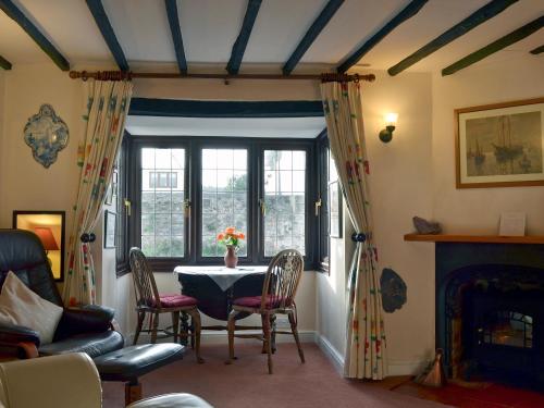 a living room with a table and a window at Bridge Cottage in Watchet