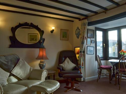 a living room with a couch and chairs and a mirror at Bridge Cottage in Watchet