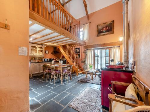 a kitchen and dining room with a table and a staircase at Y Cartws in Llanybydder