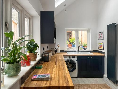 a kitchen with a wooden counter top and a washing machine at Cosy Cwtch in Hay-on-Wye
