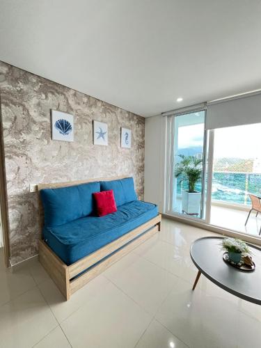 a blue couch in a living room with a table at Reserva Del Mar Apartamentos in Gaira