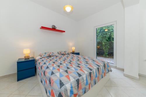 a bedroom with a bed and two night stands and a window at Beach House Kocer in Pirovac
