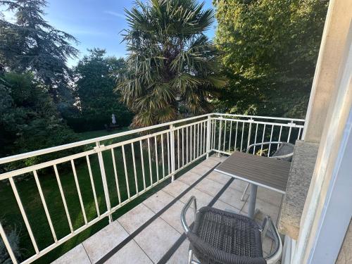 a balcony with a table and chairs on a porch at Logis Hôtel La Demeure du Perron in Quettehou