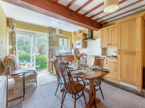 a kitchen with a wooden table and chairs in a room at Stybarrow View Cottage in Glenridding