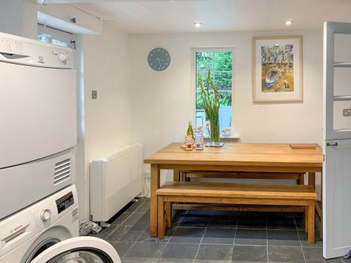 a kitchen with a wooden table and a sink at Castle Cottage in Ruan Lanihorne