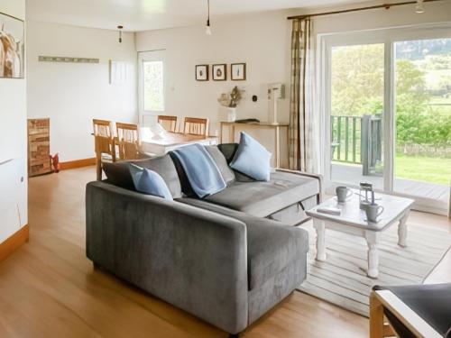 una sala de estar con un sofá y una mesa en Tay Lodge, en Aberfeldy