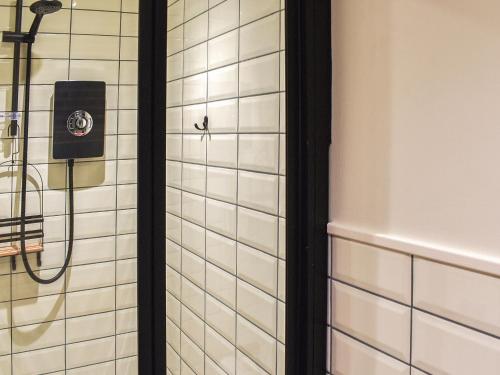a shower in a bathroom with white tiles at White Mermaid - Uk42775 in Newborough