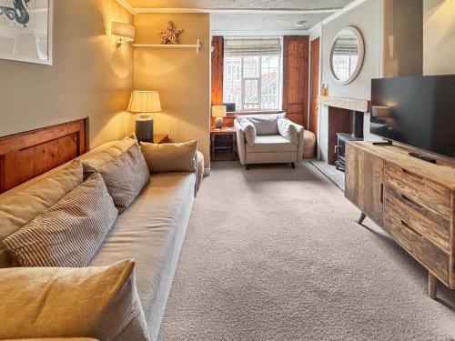 a living room with a couch and a television at Whalers Cottage in Whitby