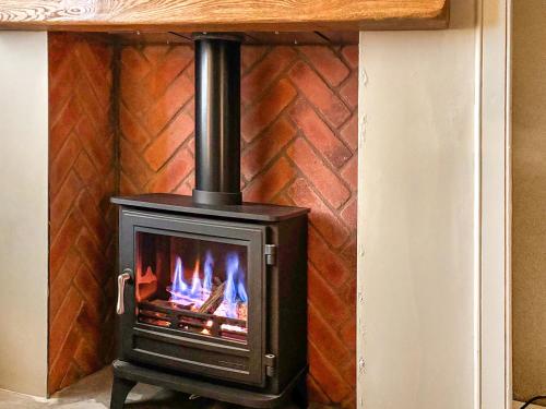 a stove in a room with a brick wall at Whalers Cottage in Whitby