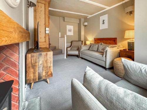 a living room with a couch and a fireplace at Whalers Cottage in Whitby