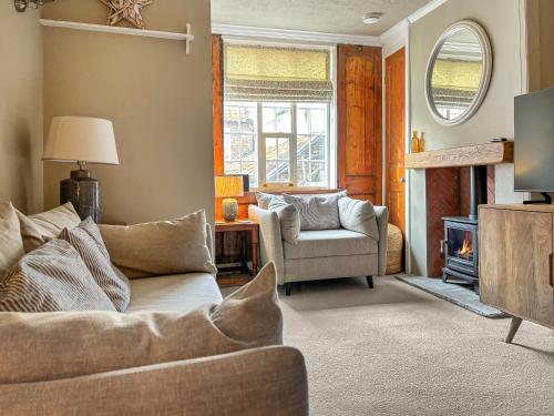 a living room with a couch and a chair at Whalers Cottage in Whitby