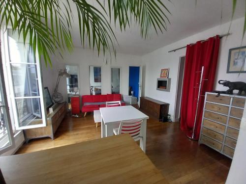 a living room with a table and a red couch at Appartement Batignolles pour 2 pers in Paris