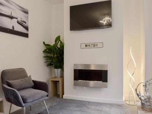 a living room with a chair and a tv on the wall at Hidden Gem in Willingham