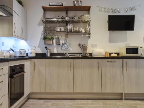 a kitchen with wooden cabinets and a microwave at Hidden Gem in Willingham
