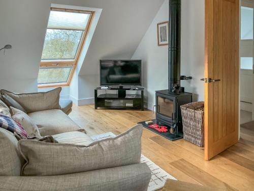 a living room with a couch and a television at Walnut Cottage Barn in Clevedon
