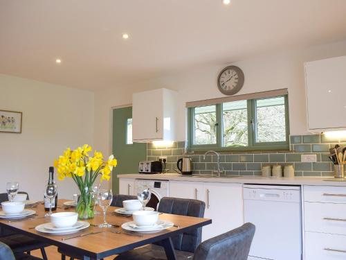 a kitchen with a table and a clock on the wall at Red Kite Lodge - Uk32610 in Old Radnor