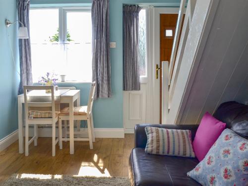 un salon avec un canapé et une table dans l'établissement Crown Courtyard Cottage, à Grewelthorpe