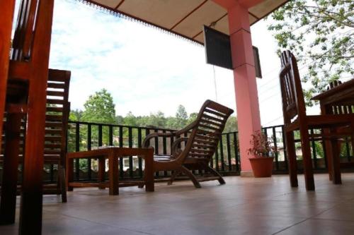 two chairs and a table on a porch at Little heaven guest in Ella
