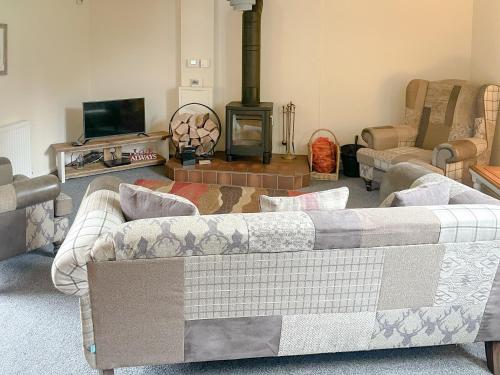 un soggiorno con divano e camino di The Boyne Arms Cottage a Burwarton
