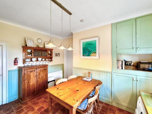 a kitchen with a wooden table in a room at Lighthouse Cottage in Happisburgh