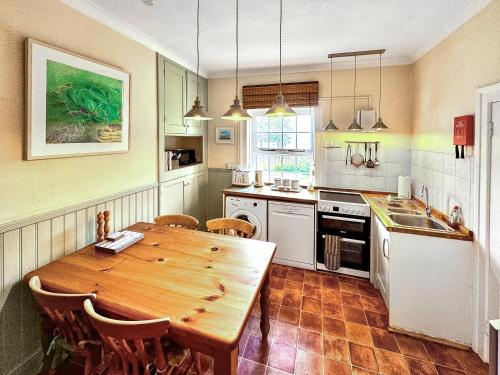 a kitchen with a wooden table and a table and chairs at Lighthouse Cottage in Happisburgh