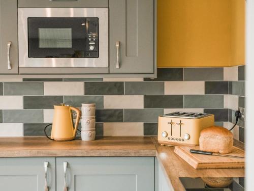 a kitchen with a counter top with a toaster and a microwave at Swallow Lodge - Uk42540 in Winforton
