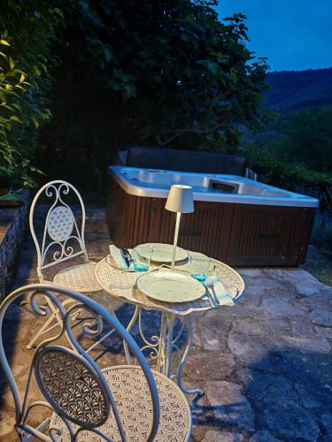 a patio with a table and chairs and a tub at Agriturismo campagna in compagnia in Vallo di Nera