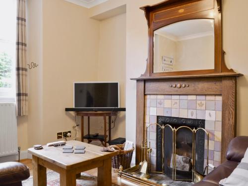 ein Wohnzimmer mit Kamin und Spiegel in der Unterkunft 18 In The Corner in Windermere