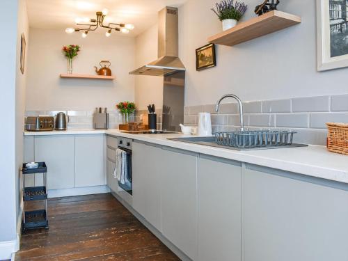 a kitchen with white cabinets and a sink at Wellesley Retreat in Hastings