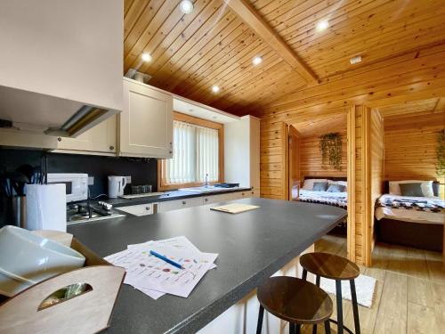 a kitchen with a counter top and a room with a bed at Magnolia Lodge-Uk46280 in Camerton