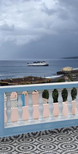 a balcony with a view of the ocean and a ship at Residência Alto Saco, Double room with private bathroom in Tarrafal