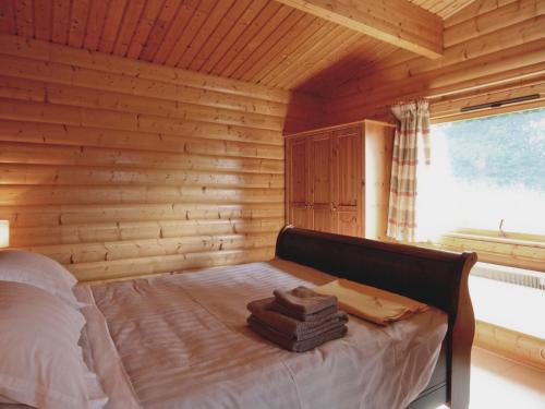 a bedroom with a bed in a log cabin at Cider Mill Lodge - Hw7420 in Tintern