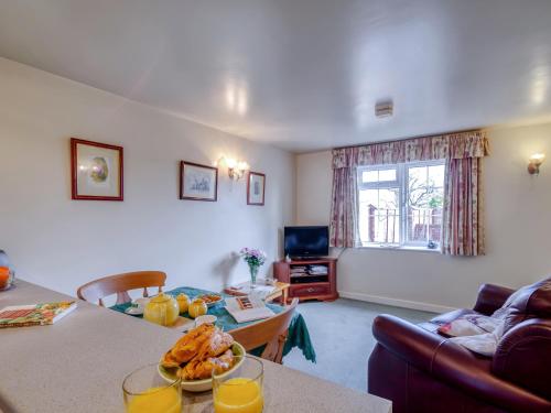 a living room with a couch and a table at Blossom Cottage in Goldsborough
