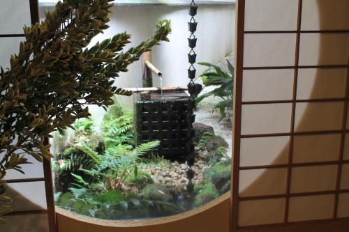 a fish tank with a water fountain in it at Oku Yugawara SANSUIROU in Yugawara