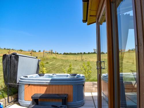 a hot tub on a patio with a view of a field at Whitey Top Country Lodge in Pentridge