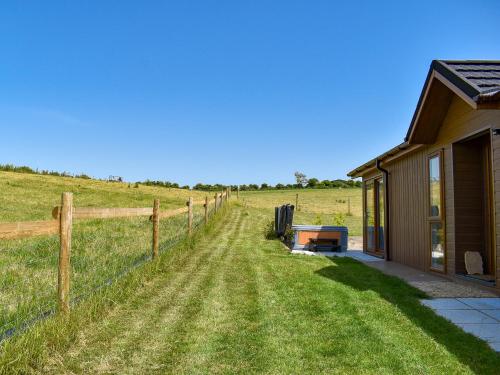 a house in the middle of a field with a fence at Whitey Top Country Lodge in Pentridge