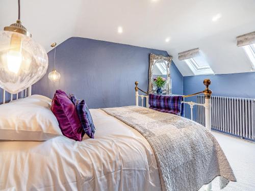a bedroom with a bed and a blue wall at Queens Barn in Wortham