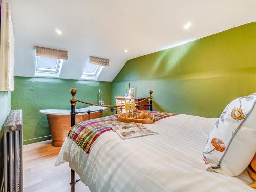 a green bedroom with a bed and a tub at Queens Barn in Wortham