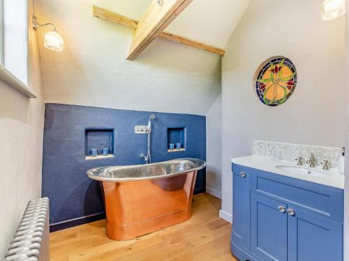 an old tub in a bathroom with a sink at Queens Barn in Wortham