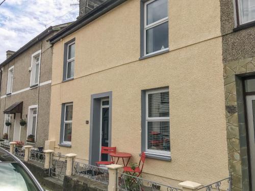 a house with a red table and chairs outside of it at Woodville in Porthmadog