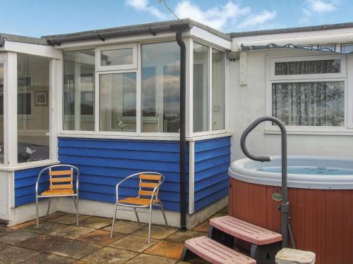 two chairs and a hot tub outside of a house at Seagull Cottage in Pagham