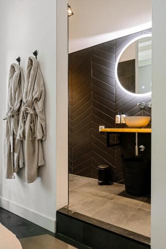 a bathroom with a sink and a mirror at B&B Cosy Woods - stijlvolle suites aan het bos! in Rhenen