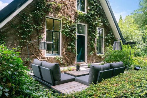 a backyard patio with chairs and a building at B&B Cosy Woods - stijlvolle suites aan het bos! in Rhenen