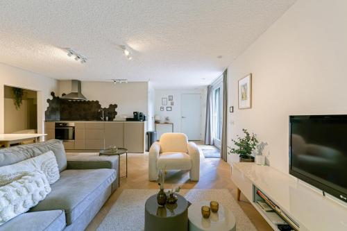 a living room with a couch and a tv at B&B Cosy Woods - stijlvolle suites aan het bos! in Rhenen