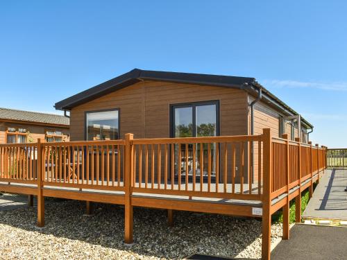 a house with a large wooden deck at Lodge 38 in Stonham Aspall