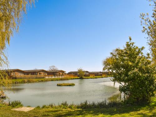 a view of a lake with houses in the background at Lodge 38 in Stonham Aspall
