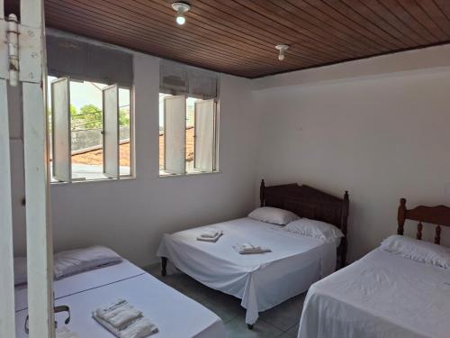 a room with two beds and two windows at Hotel Porto da Lua Belém in Belém