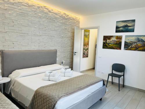a bedroom with a bed and a chair at Garda Art&City - near Sigurtà and Borghetto in Valeggio sul Mincio