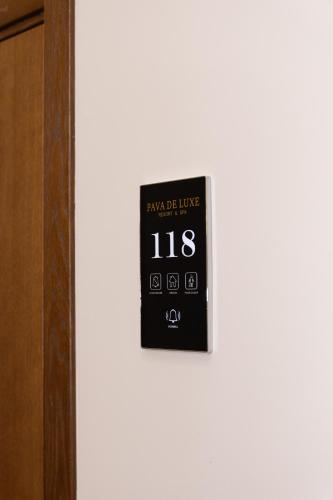 a clock on a white wall next to a door at Pava De Luxe in Berehove
