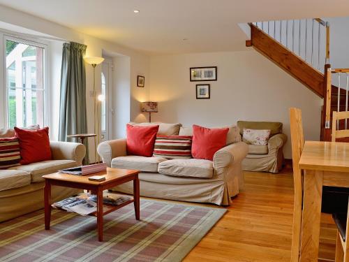 a living room with two couches and a table at Rathlin Coach House in Comrie